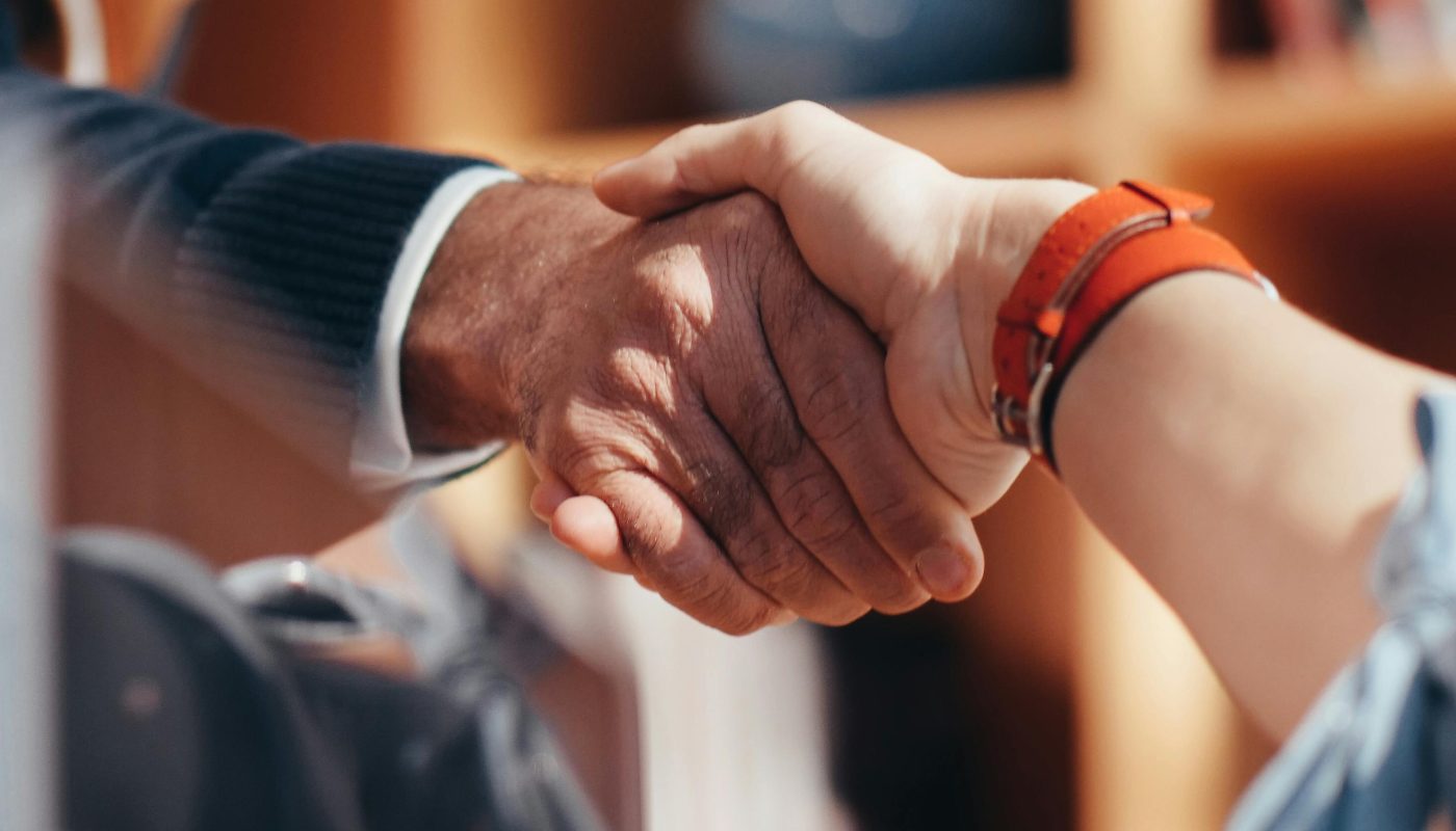 A close-up image of two people shaking hands, symbolizing a business agreement.