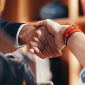 A close-up image of two people shaking hands, symbolizing a business agreement.